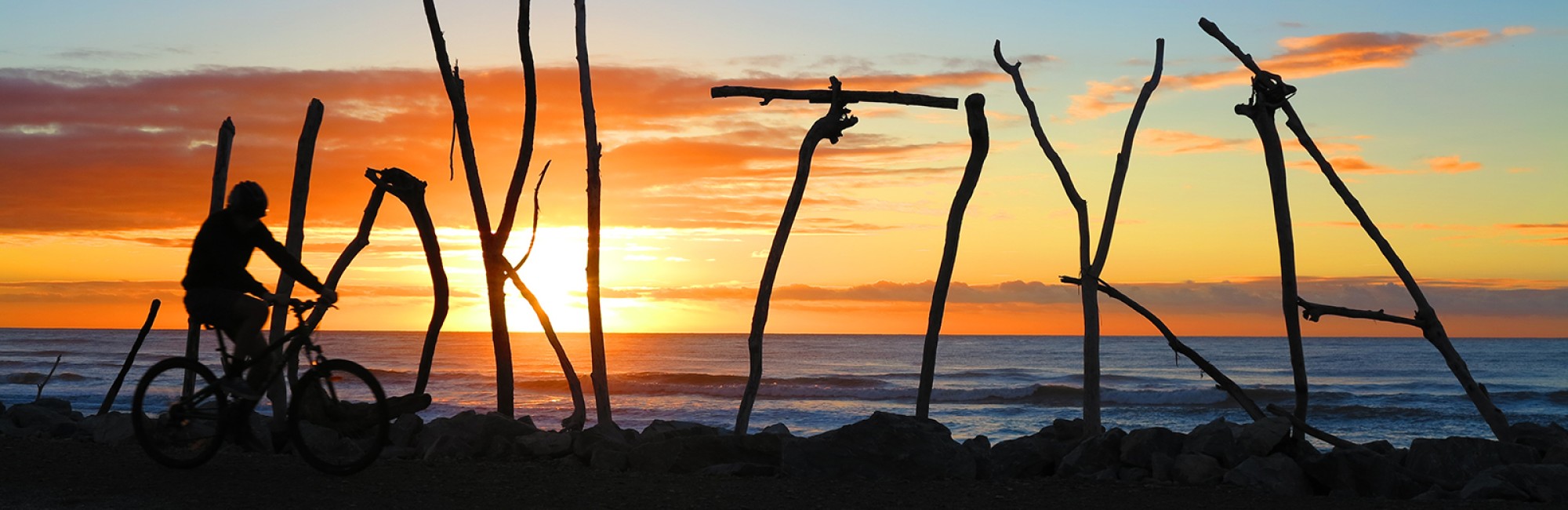 West Coast Wilderness Trail Hokitika sign bike and sunset credit Craig Wilson landing v2